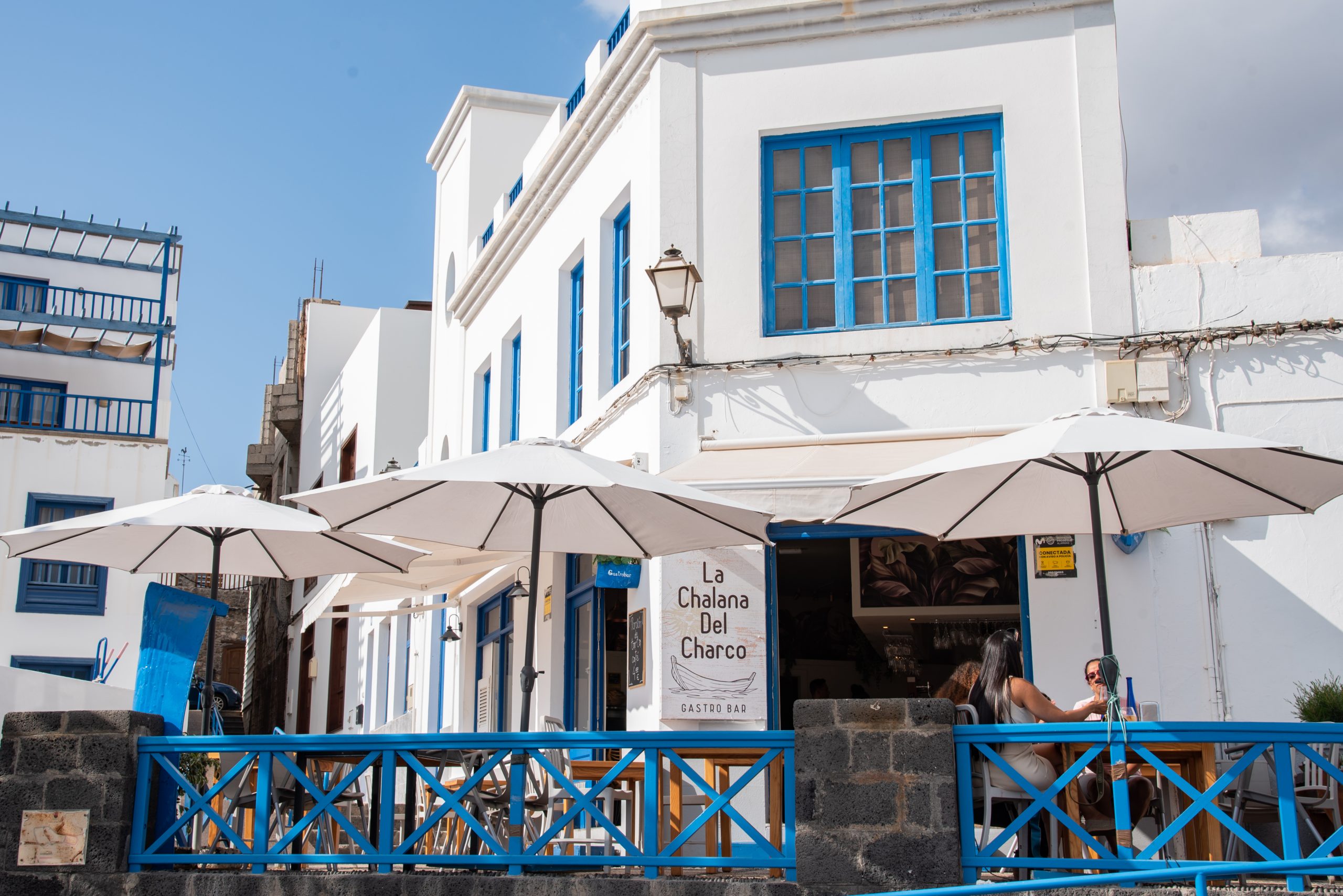 Fachada y terraza con sombrillas de La Chalana del Charco, Arrecife