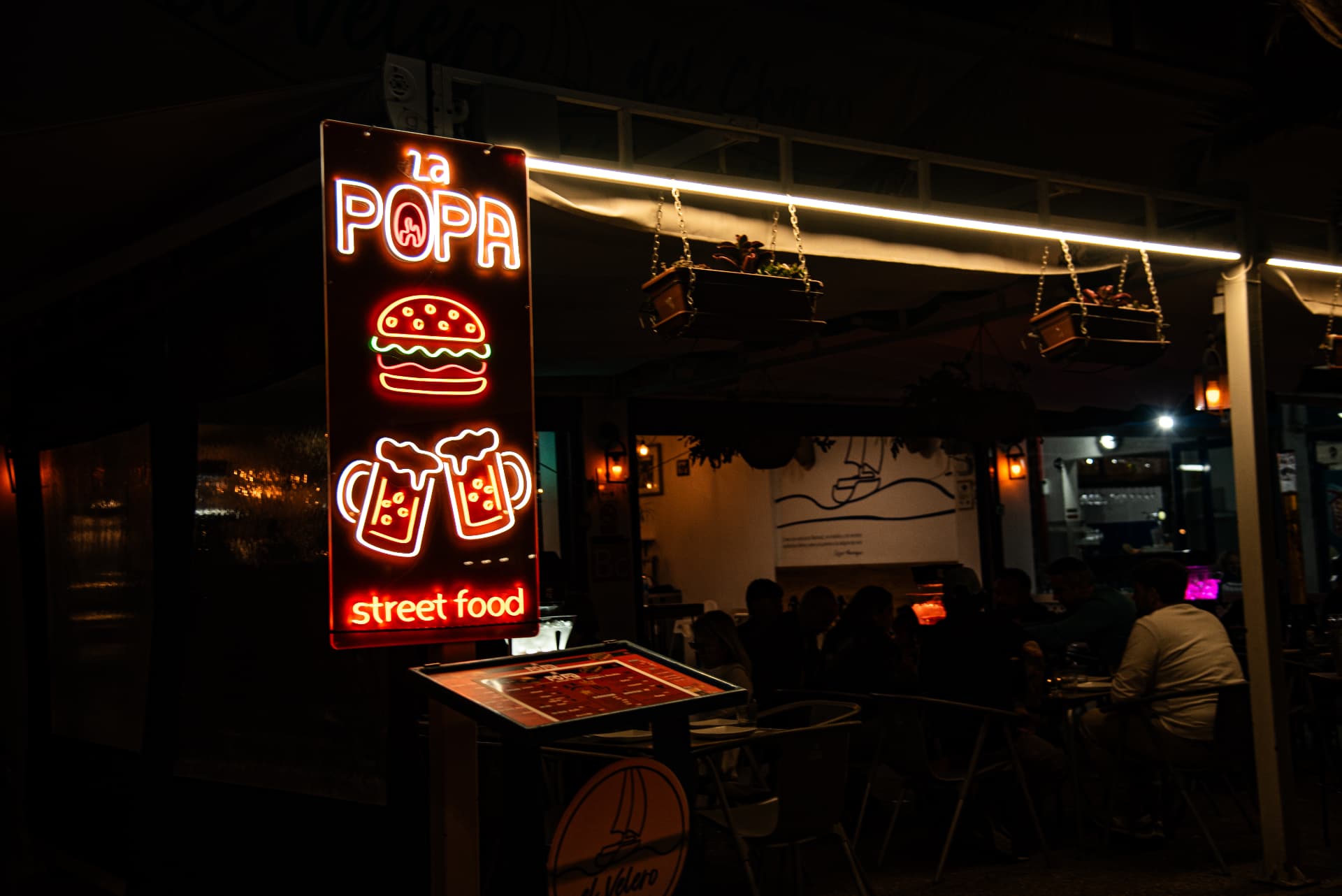 Rótulo de neón de La Popa street food iluminado de noche en Arrecife