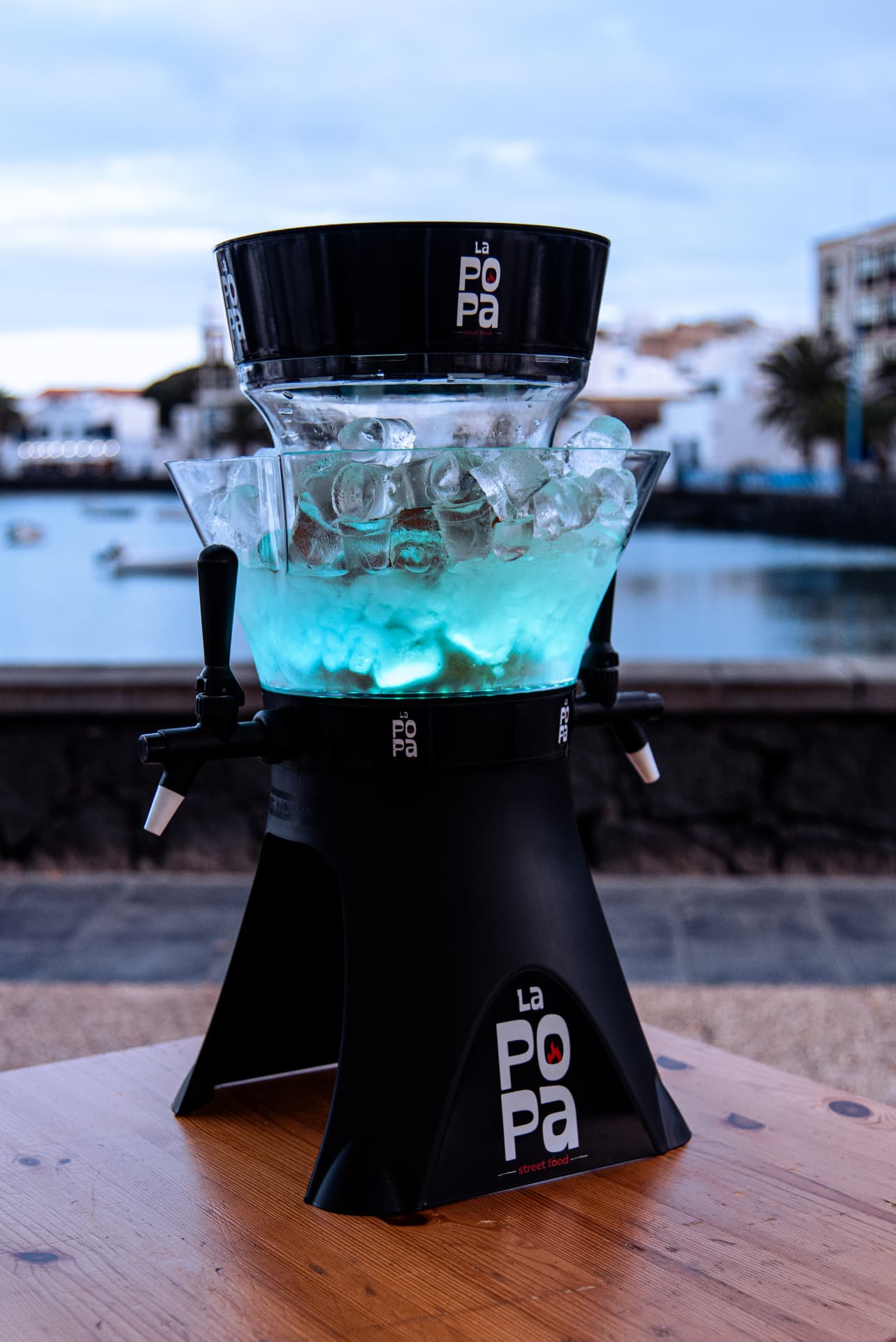 Torre de cerveza iluminada en una mesa nocturna de La Popa frente al Charco de San Ginés