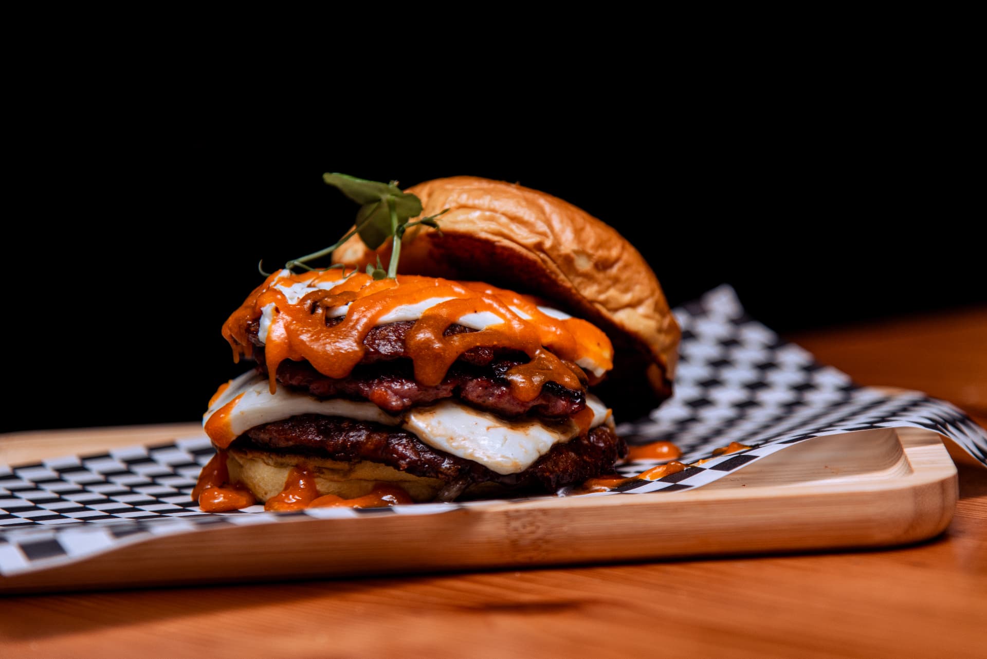 Hamburguesa doble de La Popa con salsa brava y queso fundido en pan brioche
